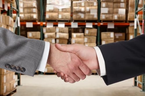 Business handshake in warehouse